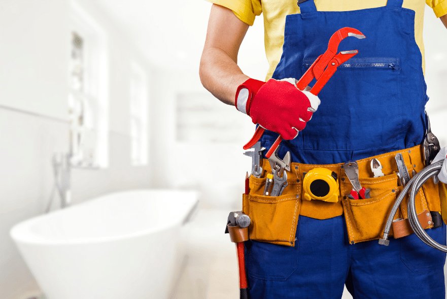 plumber with tool belt standing in bathroom